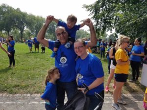 team member Phillip with his wife and two children all wearing matching blue shirts