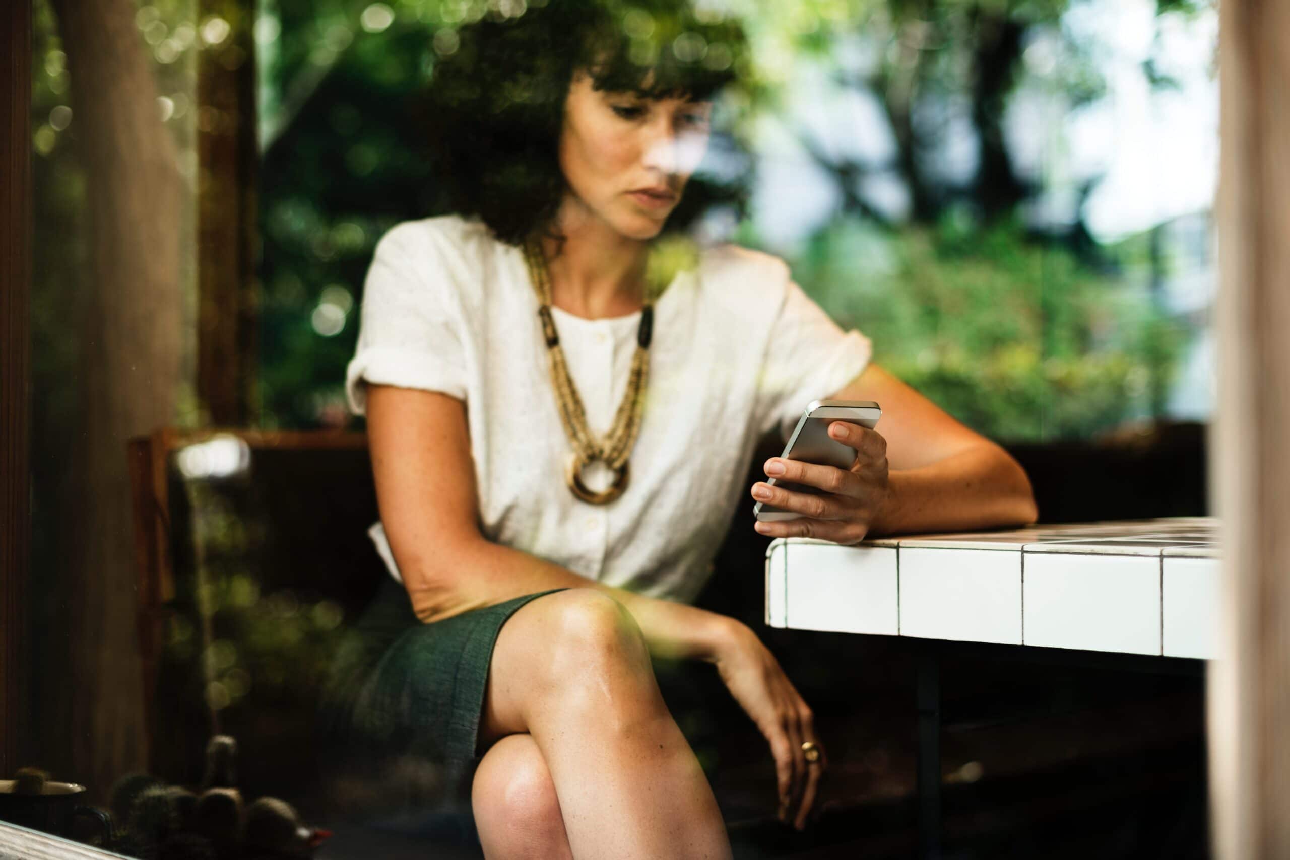 woman looking at her phone in a coffee shop