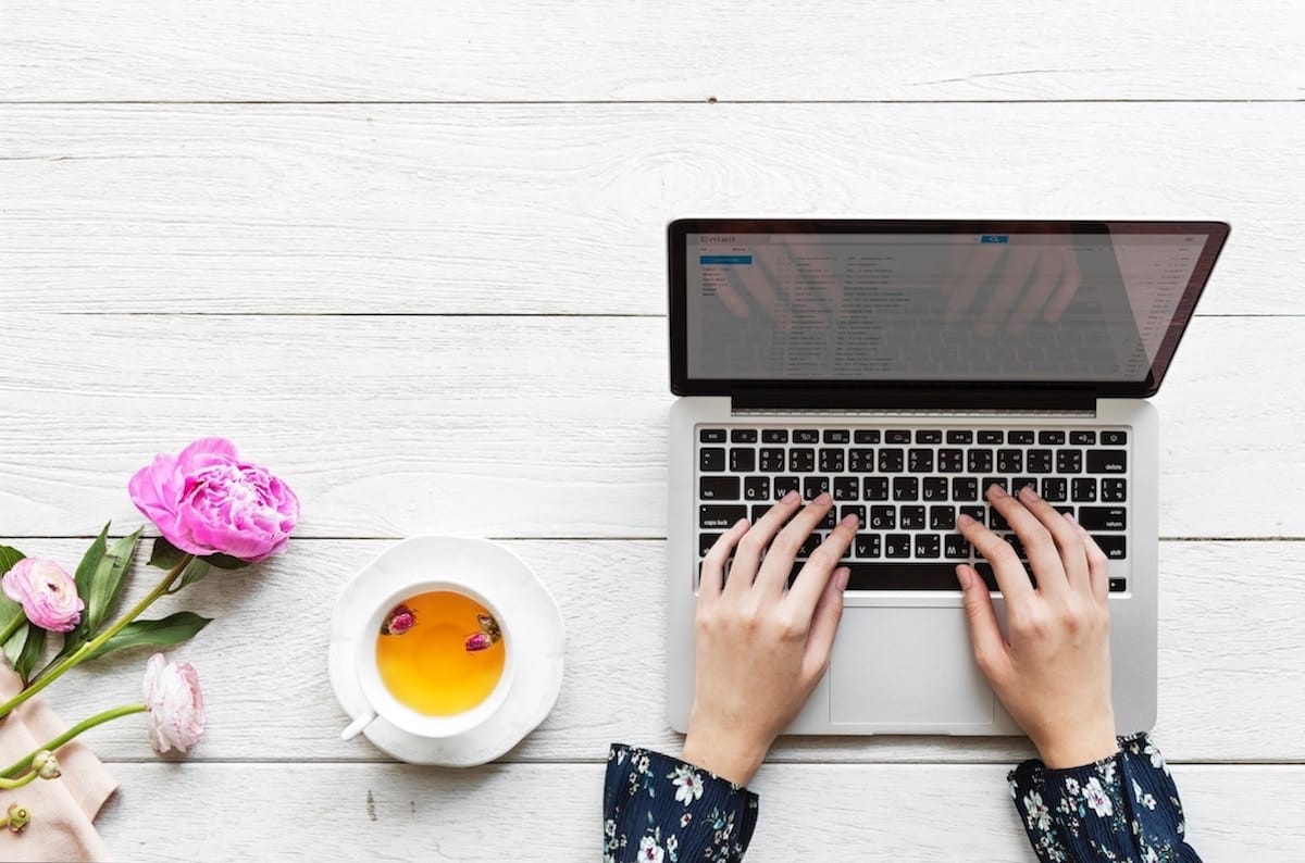 Woman's hands on laptop keyboard checking email