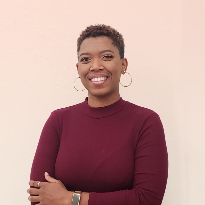 Bianca smiling, wearing a maroon shirt