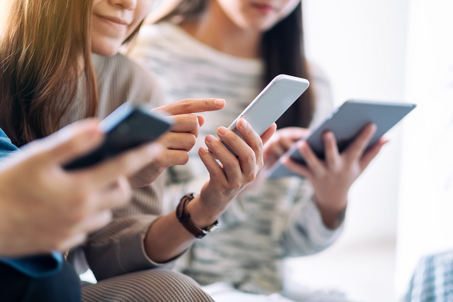 People sitting together and looking at mobile phones and tablet